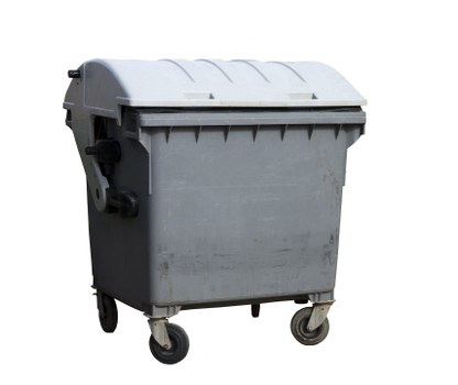 A large rectangular grey plastic wheeled waste bin with a rounded lid, situated outdoors on a concrete surface, likely on a driveway or pavement area. The bin features a textured surface and black wheel casings at the base, with the lid slightly raised at the front. It is positioned in front of a plain neutral background, with natural daylight illuminating the scene, emphasizing the matte finish of the plastic. This waste container appears suitable for rubbish collection services around Finsbury Park, providing a durable and functional exterior for waste disposal. The surrounding environment is minimal and unobstructed, highlighting the binâ€™s size and design, consistent with typical commercial or residential waste management setups used by local businesses and households in the area. Business Waste Removal Finsbury Park would typically handle such bins for effective rubbish removal in the local community.